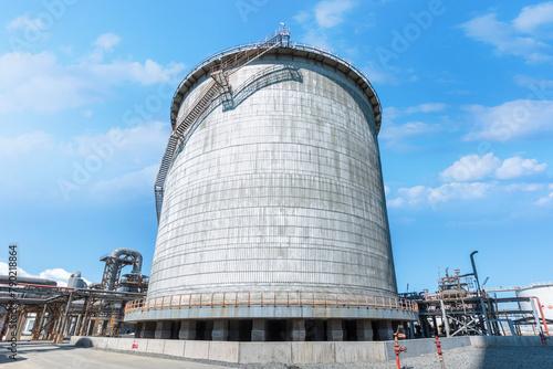 Double wall, cylindrical and vertical ammoniac storage tank in the factory. Ammonia is used in numerous different industrial application requiring carbon storage vessels. photo