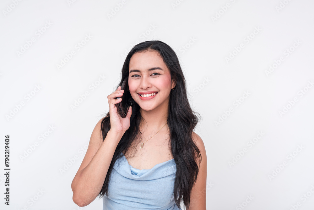 Smiling young woman in a baby blue dress talking on a cellphone Smiling young woman in a baby blue dress talking on a cellphone