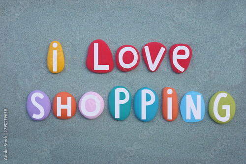 I love shopping, creative slogan composed with hand painted multi colored stone letters over green sand