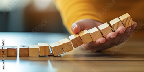 Hand Stopping the domino business crisis effect or risk protection concept, business solution and intervention