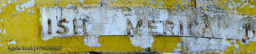 Close-up panorama section of a vintage gas station sign with missing letters and peeling paint.