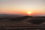 sunset over the dunes in the desert in huacachina