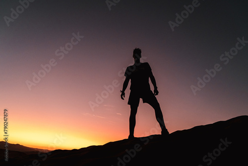 shadow of a man standing on a desert dune at sunset