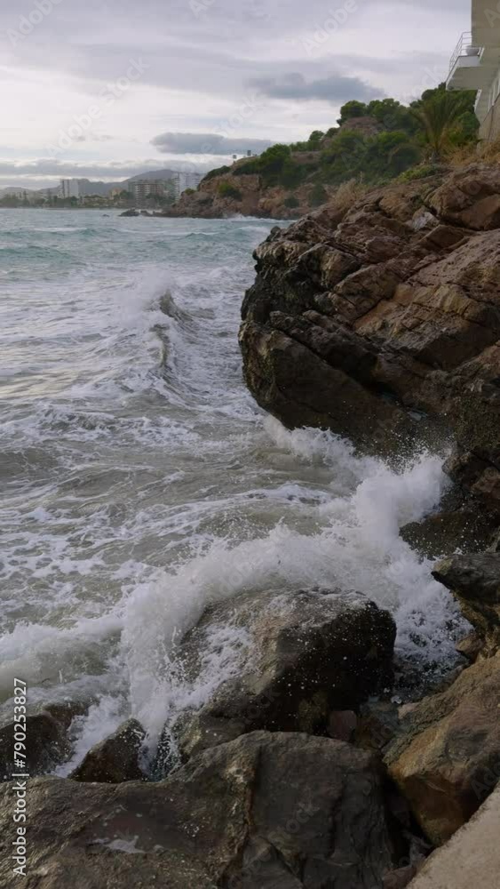 Storm at sea in spring in Benicassim. Waves crash against the rocks on a winter evening. Spain. Province of Castellon. Storm at sea in spring in Benicassim. Waves crash against the rocks on a winter evening. Spain. Province of Castellon.