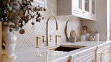 A close-up of a sink in an opulent kitchen featuring herringbone backsplash tiles. Gold faucet, white marble countertop.