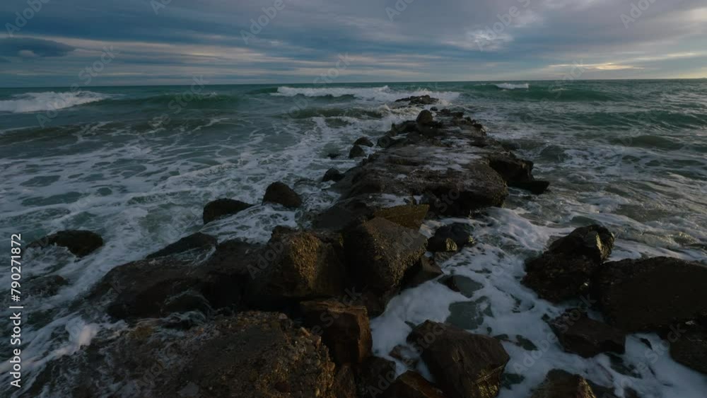 Storm at sea in spring in Benicassim. Waves crash against the rocks on a winter evening. Spain. Province of Castellon. Slow motion Storm at sea in spring in Benicassim. Waves crash against the rocks on a winter evening. Spain. Province of Castellon. Slow motion