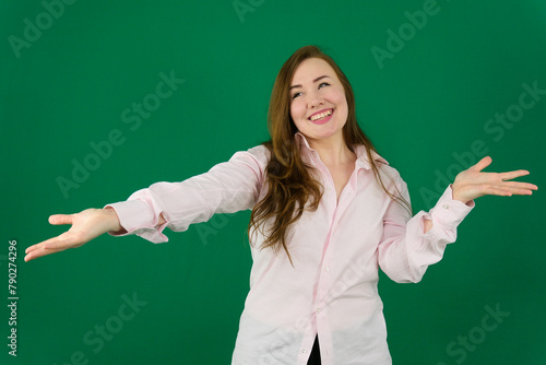 young doctor woman wearing medical uniform over green background glad cheery demonstrating copy space look novelty