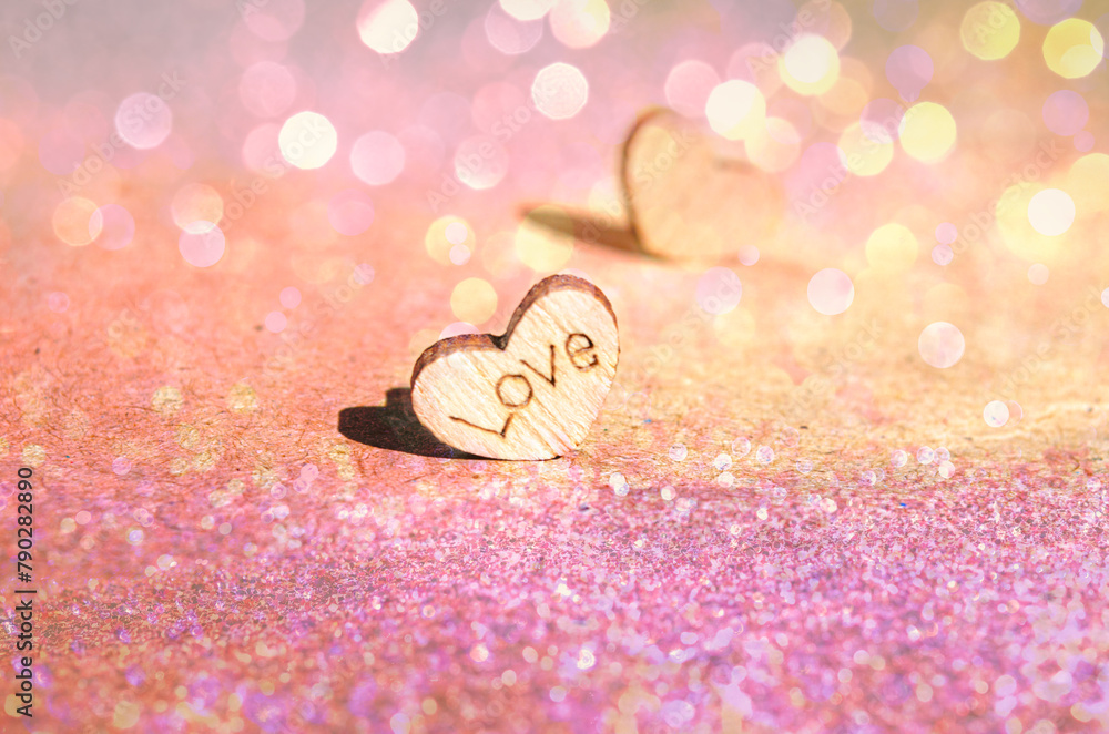 Φωτογραφία Wooden heart on kraft gold pink glitter background with inscription love in sunl