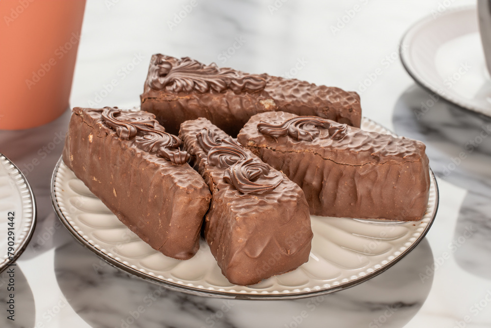Several pieces of chocolate waffle cake with white ceramic saucer and cup on marble table. Several pieces of chocolate waffle cake with white ceramic saucer and cup on marble table.