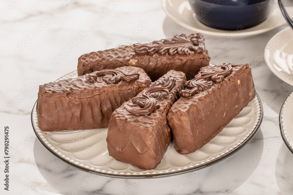 Several pieces of chocolate waffle cake on a ceramic saucer, on a table in a cafe. Several pieces of chocolate waffle cake on a ceramic saucer, on a table in a cafe.