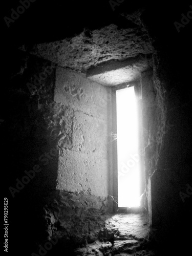 La luce filtra da una feritoia di una torre medievale. photo