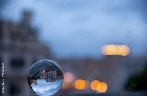 
Reflection in the crystal ball of Roman buildings under a blue hour sky, with a blue background and  bokeh colored effect, Rome, Italy