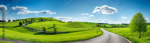 Country road meandering through green rolling hills, ideal for a tranquil rural getaway, sunny day, inviting outdoor journey photo