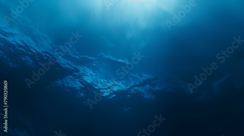 Underwater view of deep blue sea with sunlight shining through water surface