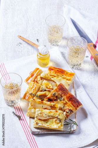 Puff pastry pie with cheese, pears, nuts and honey, served with champagne.