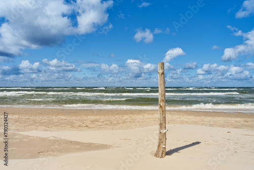 Wooden post on the sea beach. Baltic sea landscape