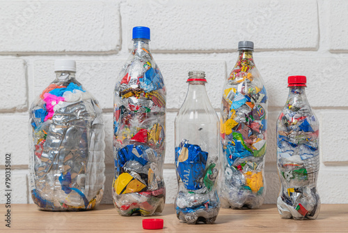 Group of four bottles of PET filled with plastic waste for upcycling and ecobricking
