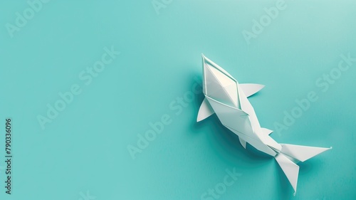 Origami shark on teal background, depicting paper art uniform color surface