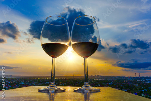 Wine Glasses in Sunset Rays with Cityscape Background