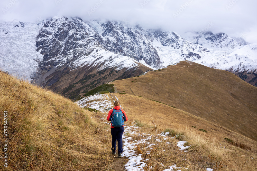 Lone Trekker Against the Snowy Backdrop of the Caucasus, Embracing the Solitude of Georgian Trails.