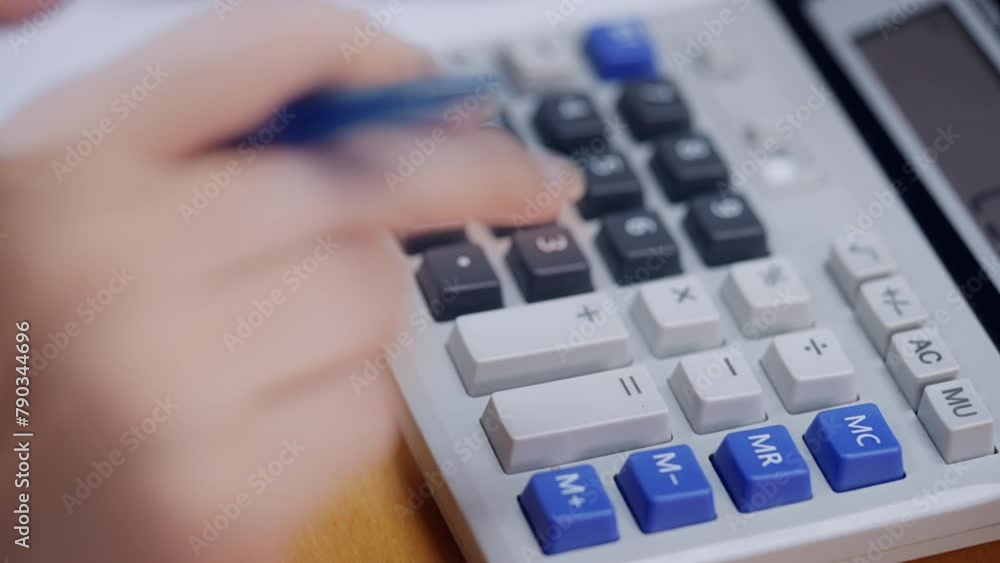A person is using a calculator with the number 3 on it A person is using a calculator with the number 3 on it