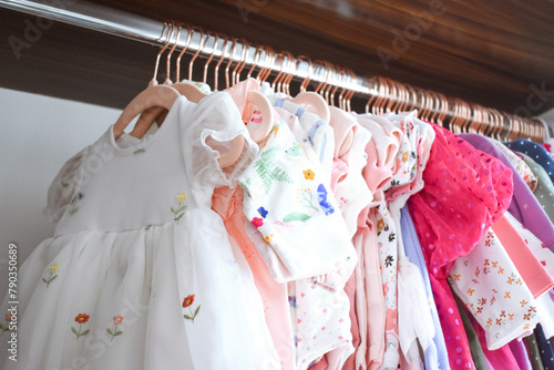 Baby girl clothes hanging in closet © Ale