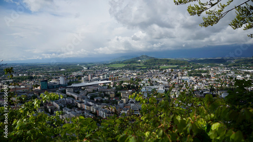 Blick auf den Hauptbahnhof und die Altstadt vom Kapuzinerberg in Salzburg mit tief dunklen Regenwolken