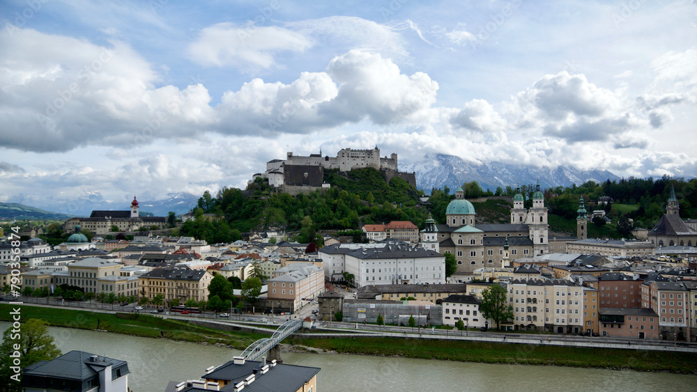 Blick auf die Festung Salzburg vom Kapuzinerberg mit der Altstadt und lockerem wolkigem Himmel bei Sonnenschein