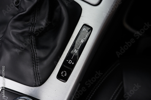 A car's gear shift is shown in black and silver. The shift is in the neutral position photo