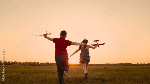 happy boy girl child play airplane pilot sunset, children family dream flying, children run together, game pilot team, childhood dreams, moment childhood, children playfully participate race with each