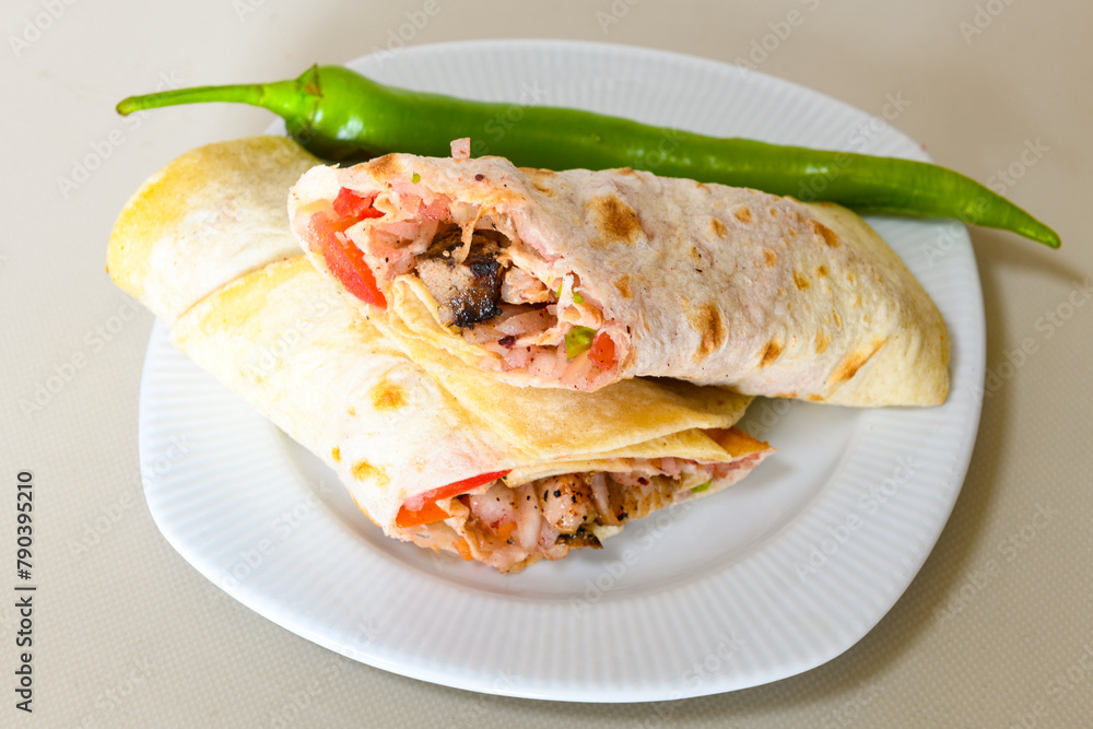 Lavash doner kebab ( zurna et tavuk doner durum ) or shawarma sliced in plate isolated. Lavash doner kebab ( zurna et tavuk doner durum ) or shawarma sliced in plate isolated.