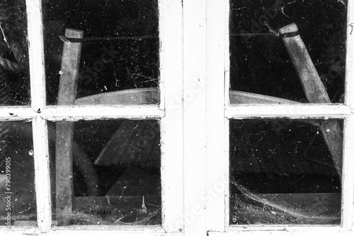 Old wooden tools behind the window. A soft handle is visible through the dusty window horizontal.