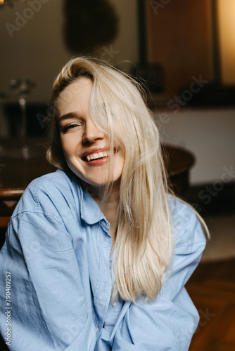 Carefree spontaneous moment of a young blonde woman smiling.
