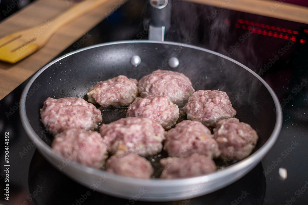 Sizzling meatballs cooking in a skillet, with steam rising, capturing the essence of home cooked comfort food in a kitchen setting. Sizzling meatballs cooking in a skillet, with steam rising, capturing the essence of home cooked comfort food in a kitchen setting.