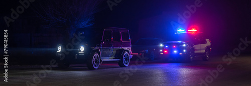 police car stands next to a car he pulled over for speeding, reaching for the driver's ID. , stock photo