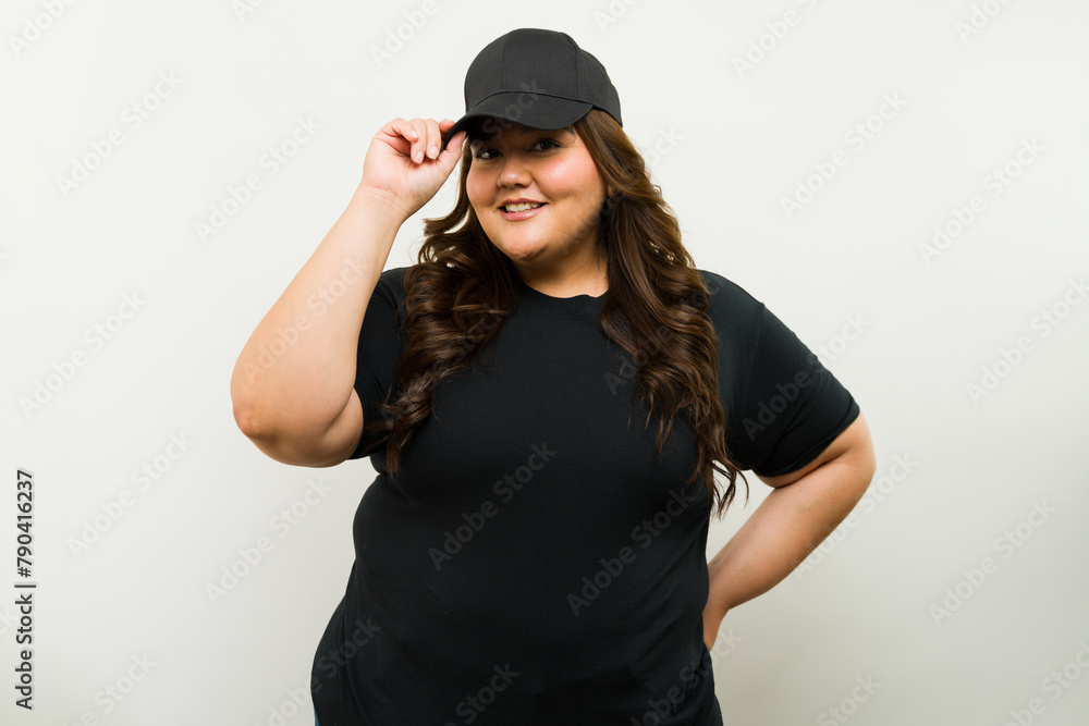 Mockup shot of a big woman wearing a black cap and t-shirt against a white background in a studio Mockup shot of a big woman wearing a black cap and t-shirt against a white background in a studio