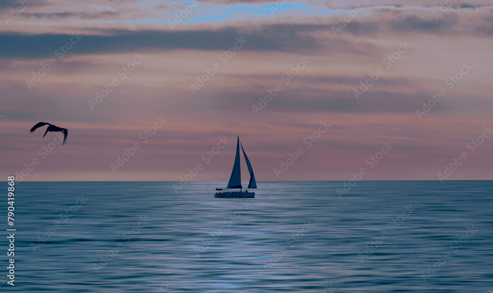 Seascape with a sailboat at sunset.