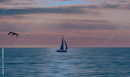 Seascape with a sailboat at sunset. © abelardo