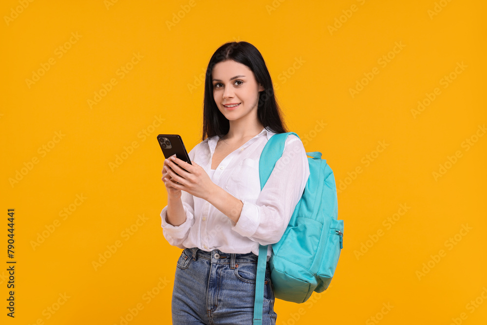 Smiling student with smartphone on yellow background Smiling student with smartphone on yellow background