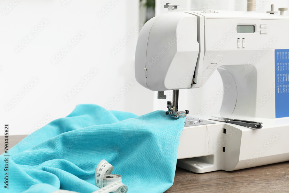 White sewing machine and cloth on wooden table indoors
