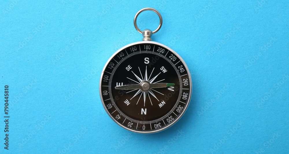 One compass on light blue background, top view One compass on light blue background, top view