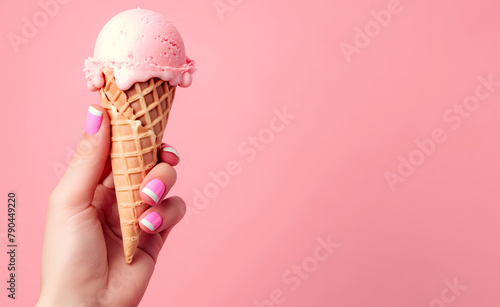 mano de mujer sosteniendo un helado con fondo rosa
