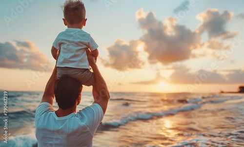 Father's day. Father and baby son playing together outdoors on summer beach photo