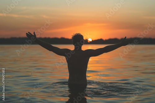 Silhouette of a man is in the water, arms raised with beautiful dawn light. Summer vacation concept, background © top images