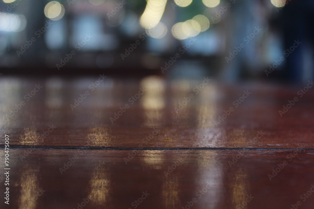 Empty wooden table top on blurred light gold bokeh in cafe restaurant with blurred lights background