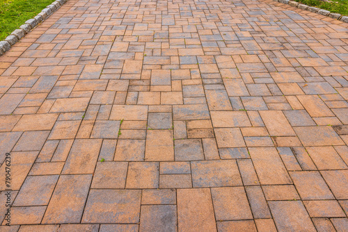 A close-up view of the red stone pathway alongside the lawn.