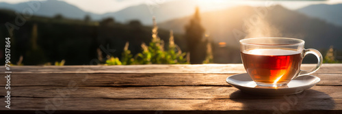 Cup of tea on wooden table with mountain background. Panoramic view