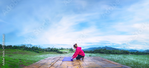 Asian woman relax in the holiday. Play if yoga. On the balcony landscape Natural Field.papongpieng in Thailand