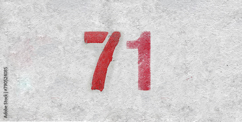 Red Number 71 on the white wall. Spray paint.