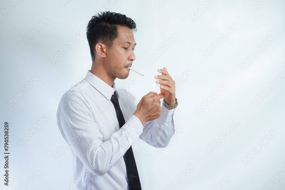 Handsome cool man with Cigarette, going to smoke, isolated on white background, copy space for advertisement. Portrait of asian man in white shirt light cigarette. copy space. Smoking concept Handsome cool man with Cigarette, going to smoke, isolated on white background, copy space for advertisement. Portrait of asian man in white shirt light cigarette. copy space. Smoking concept